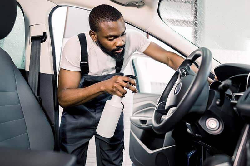 Man detailing the dashboard of a vehicle